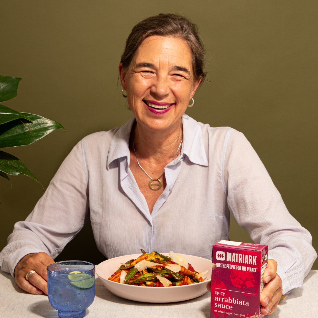 Photo of Anna Hammond with a carton of Matriark Spicy Arrabbiata Sauce and a bowl of pasta