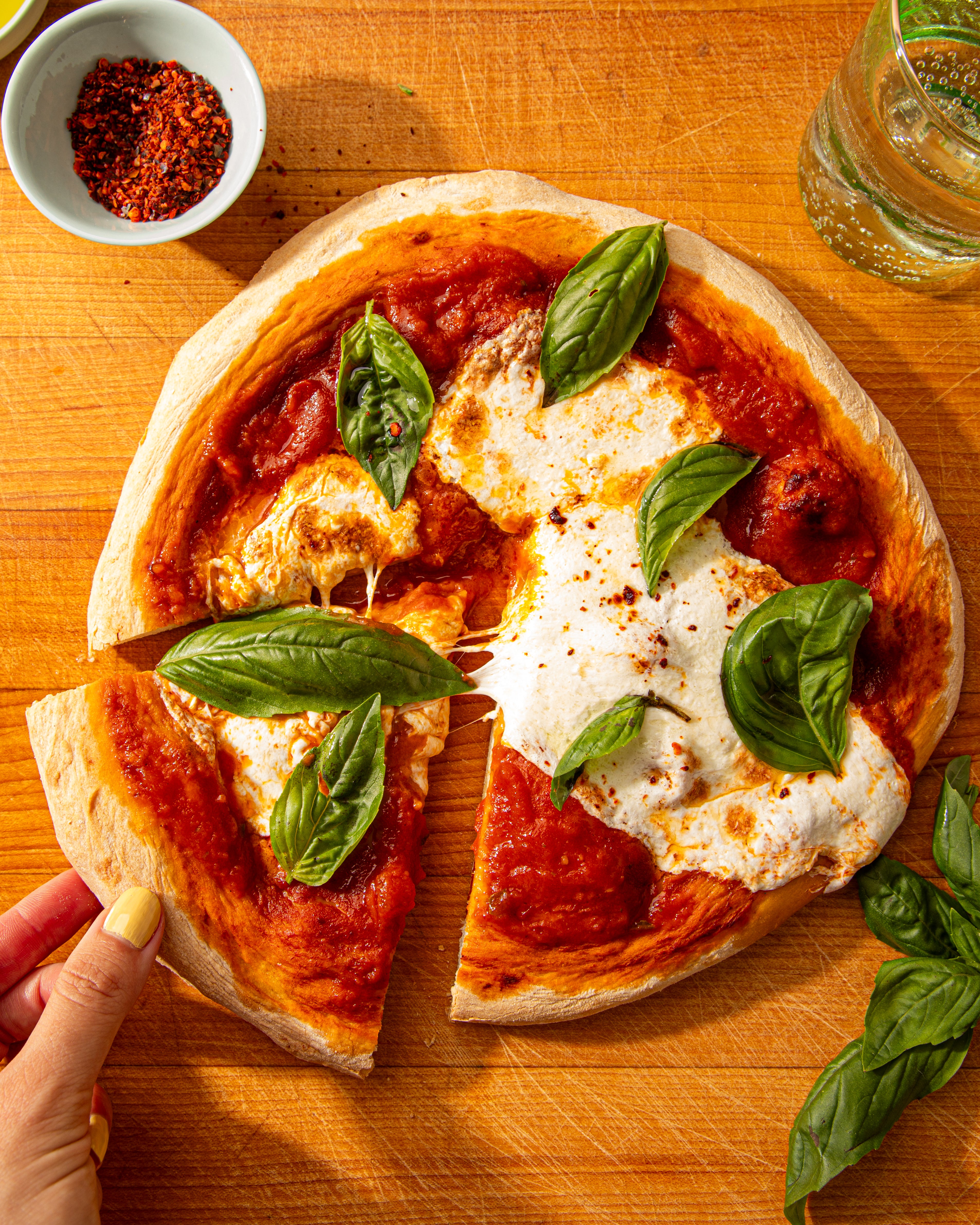 Margherita pizza made with Matriark tomato sauce, with a slice being taken.