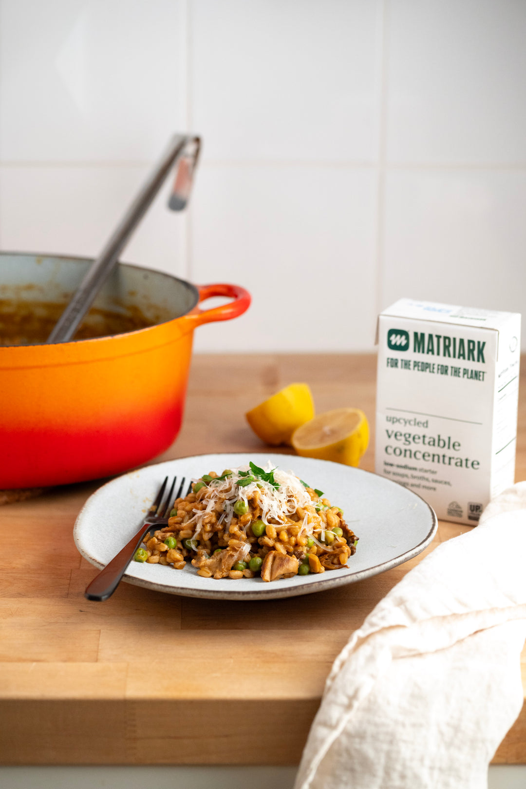 Matriark's Upcycled Vegetable Concentrate, a plate of risotto and a dutch oven sitting on a countertop.